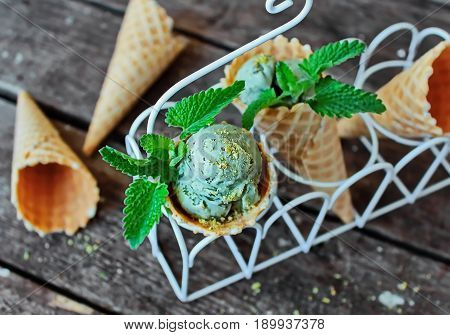pistachio ice cream in a waffle cone and fresh mint - top view on the right