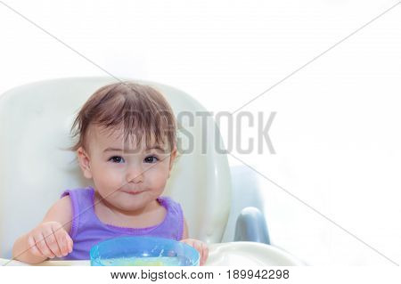 baby eating in the kitchen on the sittting on the table