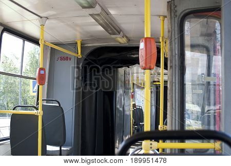 Interior of an empty old tram with open doors.
