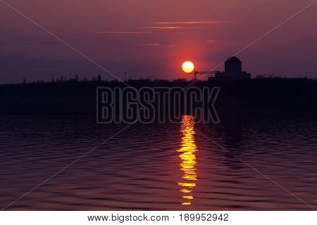 Crimson sunset at Voronezh water reservoir. Silhouette of nuclear power plant