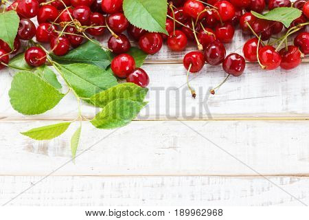 Ripe cherries on wooden table. View from above with copy space