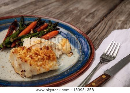 White Flakey Sea Bass With Breadcrumbs And Roasted Asparagus And Carrots