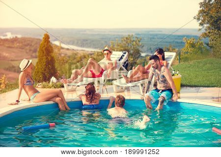 Young group enjoying in swimming pool at summer