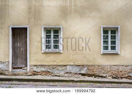 Old two windows and door with grunge cracked wall