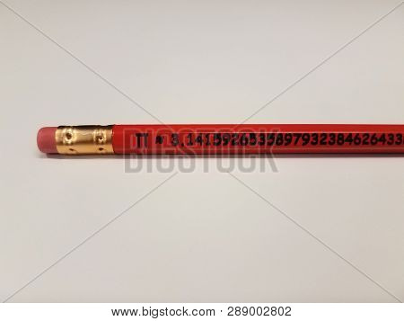Orange Wood Pencil With Mathematical Constant Pi On White Surface