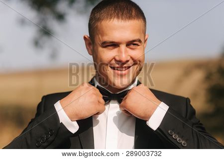 Handsome Groomm Dressed A Tie Bow. Wedding Day. Man Outside