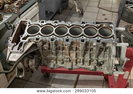 Replacement Six Cilinder Engine Used On A Red Crane Mounted For Installation On A Car After A Breakd