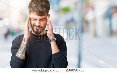 Young handsome man over isolated background with hand on head for pain in head because stress. Suffering migraine.