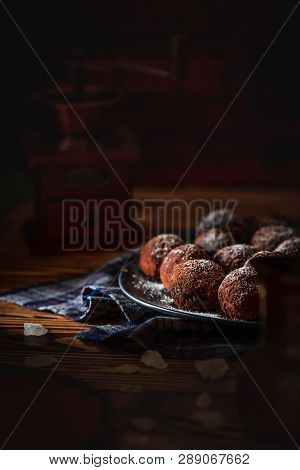 Chocolate Truffles On A Dark Plate On A Wooden Table Diffused With Powdered Sugar On A Dark Backgrou