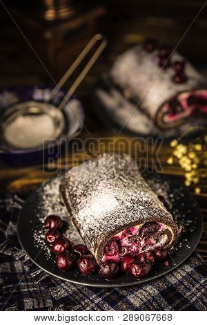Cherry Roll On A Plate With Cherries On A Checkered Napkin On The Table
