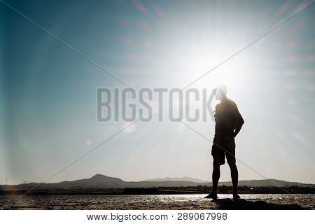 Single Man Walking On Dry Salt Lake In Limassol, Cyprus. Alone And Walking In Desert Conditions.