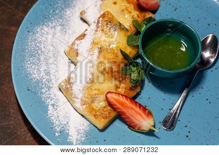 Pancakes With Strawberries On A Blue Plate