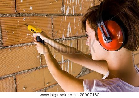 Laborer หญิงทำหลุม ด้วย screwgun การ