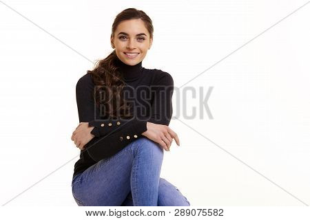 Cheerful Young Woman Sitting At Isolated White Background