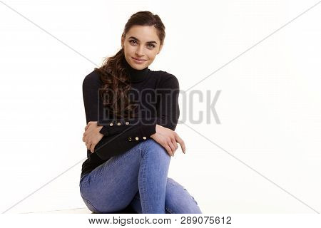 Attractive Smiling Young Woman Sitting At Isolated White Background