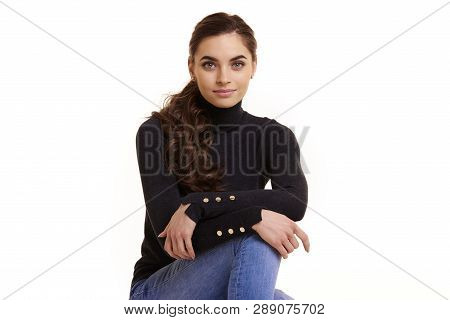 Attractive Smiling Young Woman Sitting At Isolated White Background
