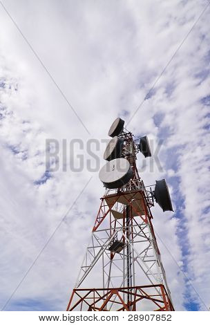Antena de telecomunicaciones bajo cielo nublado.