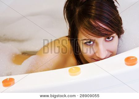 สาวในอ่างจากุซซี่ตกแต่งจ้องกล้อง