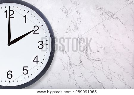 Closeup Of Wall Clock Show Two Oclock On White Marble Background