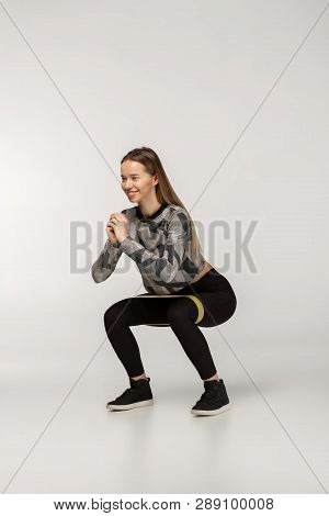 Young Sporty Woman Squatting Doing Sit-ups With Resistance Band