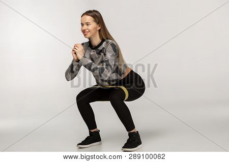 Young Sporty Woman Squatting Doing Sit-ups With Resistance Band