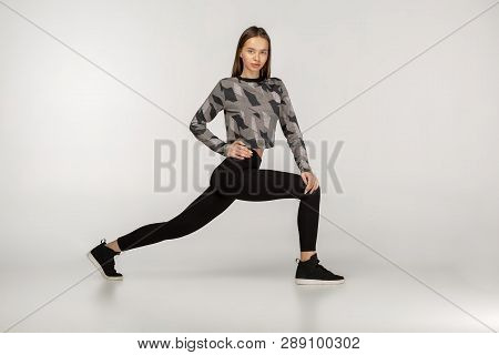 Sporty Yogi Brunette Girl In Dark Sportswear Doing Exercises