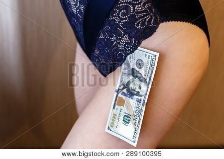Young Woman Dressed In Blue Lingerie Hold A Money, New One Handred Dollars Banknote.