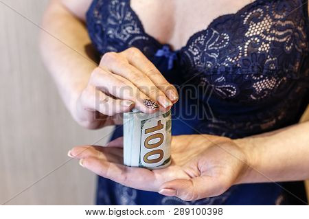 Young Woman Dressed In Blue Lingerie Hold A Money, New One Handred Dollars Bank Notes.