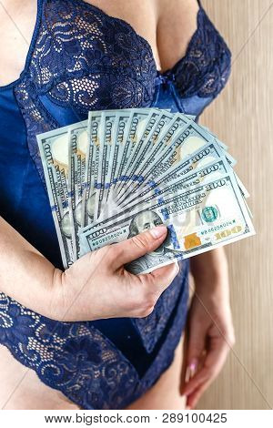 Young Woman Dressed In Blue Lingerie Hold A Money, New One Handred Dollars Banknotes.