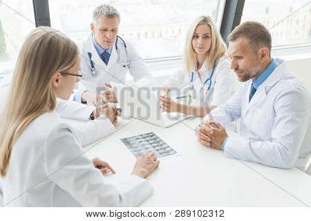 Team of doctors working in the office discussing brain MRI scan