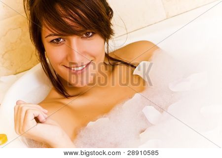 สาวในอ่างจากุซซี่ตกแต่งจ้องกล้อง