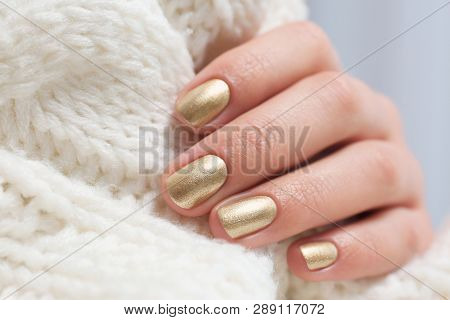 Woman With Golden Manicure Holding Knitted Fabric, Closeup. Nail Polish Trends