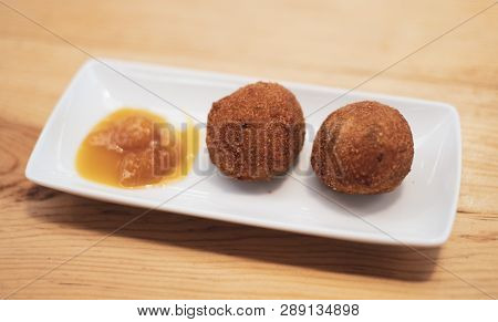 Deep Fried Croquettes On A Plate With Sauce