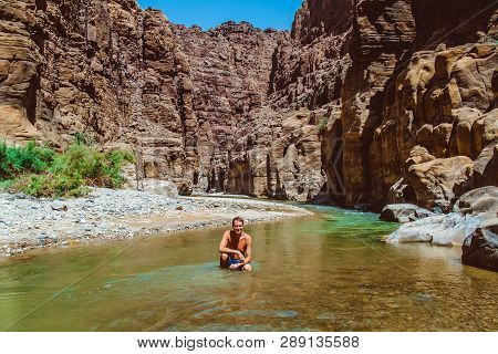 Young Adventurous Man In Wadi Zarqa Ma'in Canyon Located In The Mountainous Landscape To The East Of