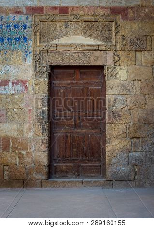 Cairo, Egypt - November 3 2018: Old Wooden Door Framed By Bricks Stone Wall At The Courtyard Of Al R
