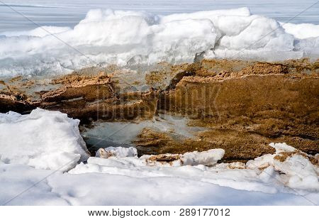 Blocks Of Ice Melt In The Spring On The Shore Of The Pond