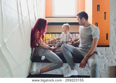 The Father, Mother And Sons Sitting On The Stairs.