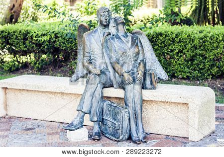 Bench With Metal Sculpture Of A Man And A Woman In Parco Colonna, Famous Public Park In Taormina, Si