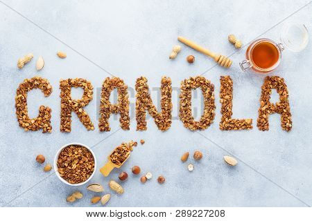 Healthy Oat, Nuts And Honey Granola Background. Word Granola Made Of Baked Oats.
