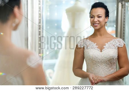 Beautifu bride choosing wedding dress in a wedding salon