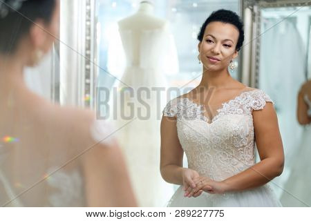 Beautifu bride choosing wedding dress in a wedding salon