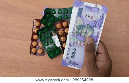 Concept Of The Persons Hands Buying Pills Or Tablets With Indian Currency