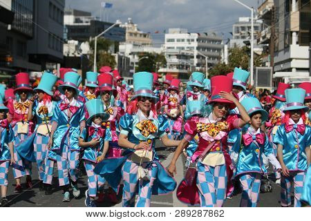 Limassol, Cyprus, March 10th, 2019: Group Of People In Bright Carnival Costumes And Top Hats Walking