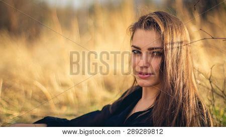 A Beautiful Brunette Girl Posing In A Field On Autumn.art Photo.
