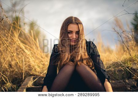 A Beautiful Brunette Girl Sitting On Stairs. Autumn. Art Photo.