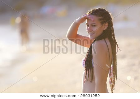 Unge smukke bikini pige på kysten ved tidlig solnedgang.