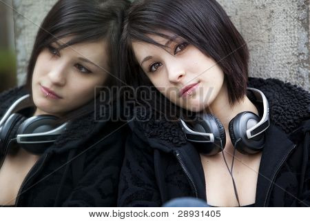 Joven hermosa chica urbana mirando en el espejo