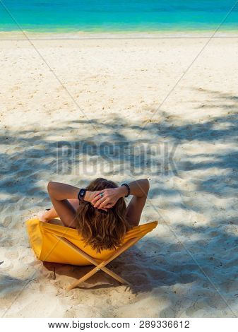 Woman enjoying her holidays on a transat at the tropical beach in Thailand