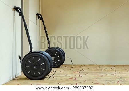 Two Wheeled Scooters On Charge. Stand Against The Wall.