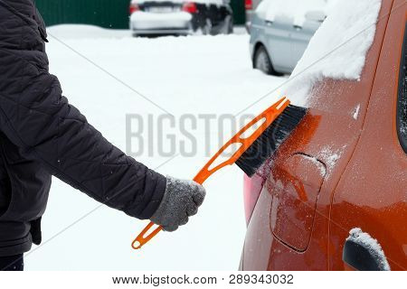 Man Brushing And Shoveling Snow Off Car After Snow Storm. Brush In Mans Hand. Winter, Snow, Vehicle.